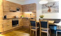 Komfortable Wohnküche mit Esstisch, Couch und Wand-TV